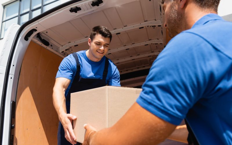 selective-focus-of-loader-holding-cardboard-box-wi-2023-11-27-05-11-16-utc.jpg